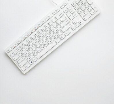 A modern white keyboard on a white background showcasing minimalist design and clean aesthetics.