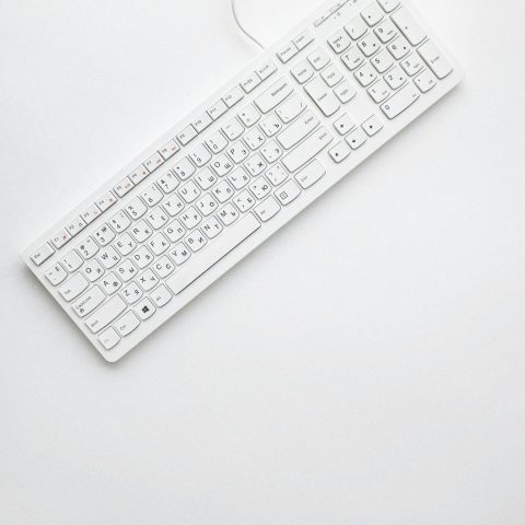 A modern white keyboard on a white background showcasing minimalist design and clean aesthetics.